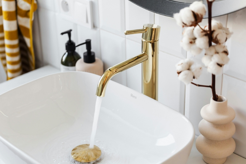Gold luxury bathroom faucet over a modern vessel sink, representing premium faucet costs in 2026.