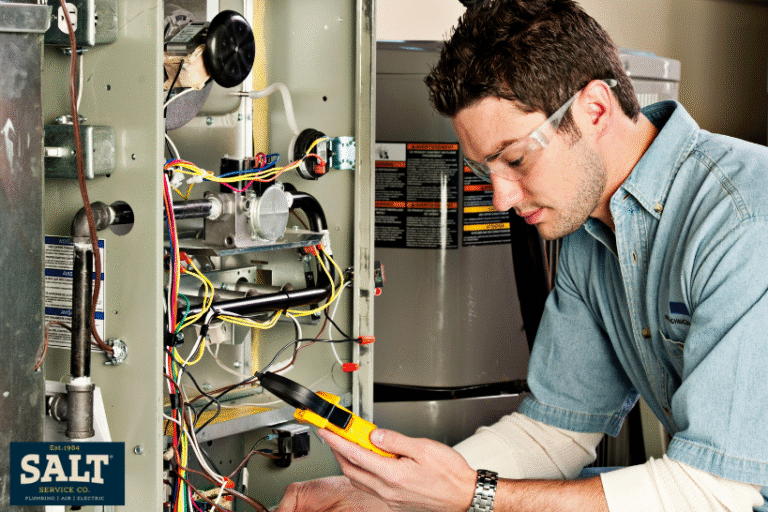 HVAC technician using a multimeter to test wiring inside an open furnace unit, wearing safety glasses during a residential service call.