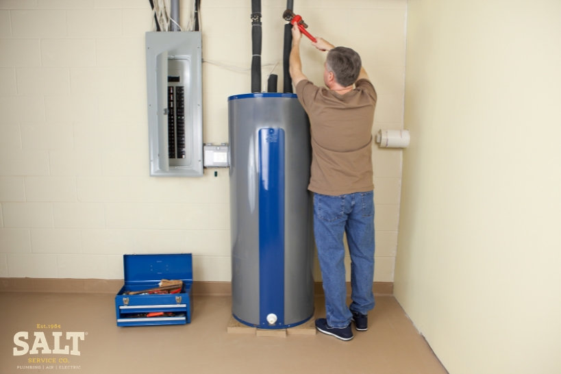 Technician replacing a residential water heater during a service visit in Austin, TX.